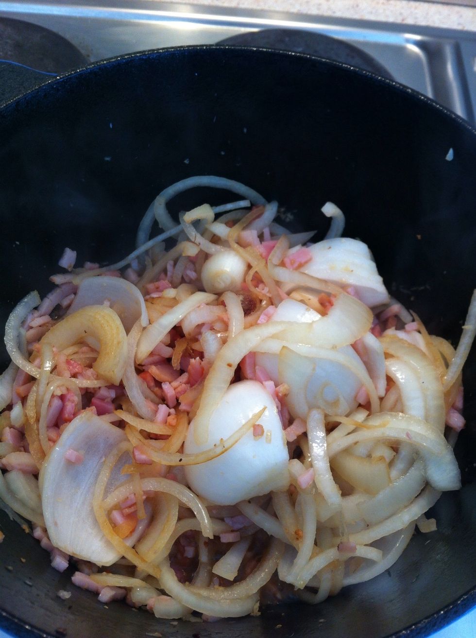 Set the lamb aside, put in chopped bacon and onions, till onions start to soften, splash some white wine, stir and let the wine boil down until reduced to a sticky glaze