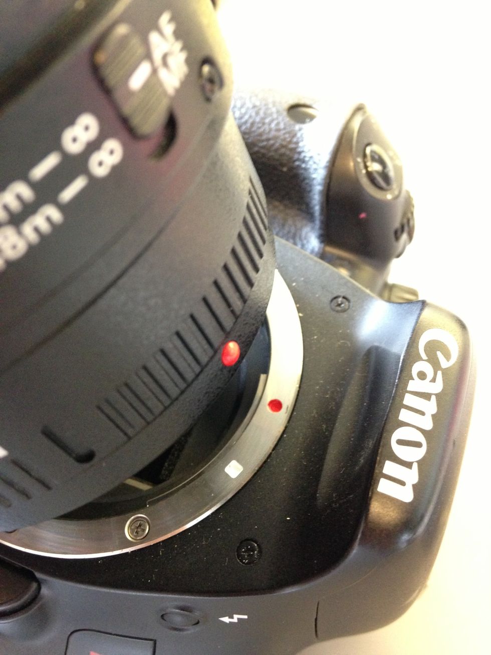 Set the lens in the camera by matching up the red dot on the lens with the red dot on the camera. Twist the lens clockwise until you hear a click. Check that the lens is secure.