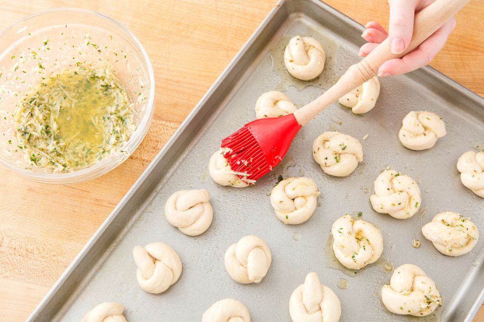 Set them on a greased cookie sheet and brush with the butter mixture.