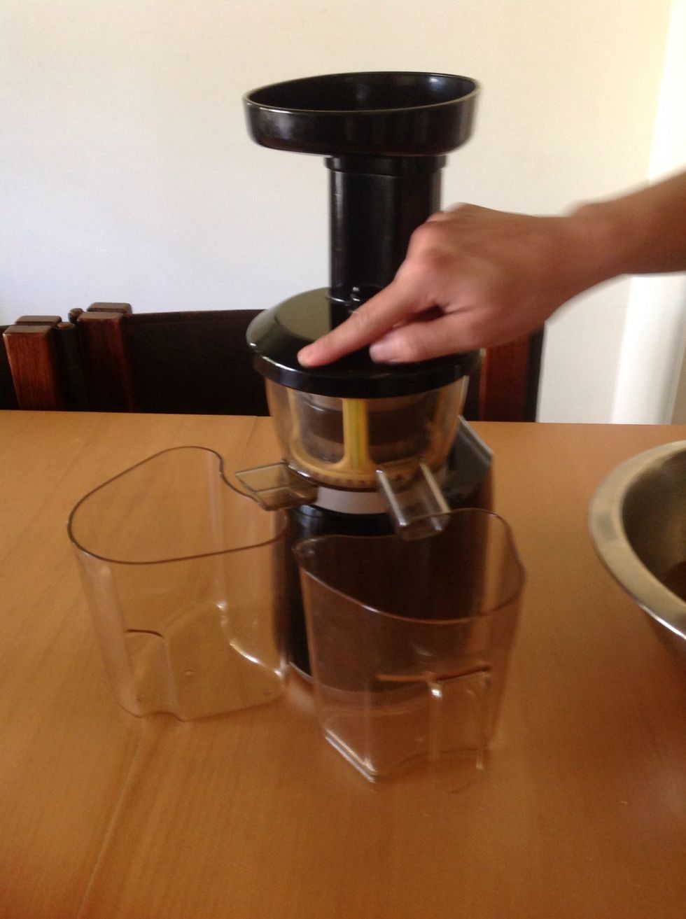 Set up the juicer. One container will collect the almond meal; one container will collect the almond milk. Plug it in and switch it on.
