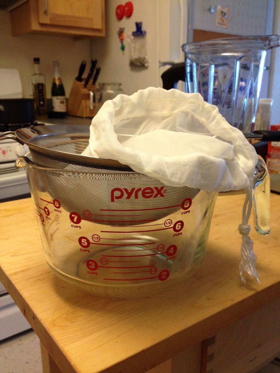 Set up the nut bag, strainer and large measuring cup (or bowl) like this.