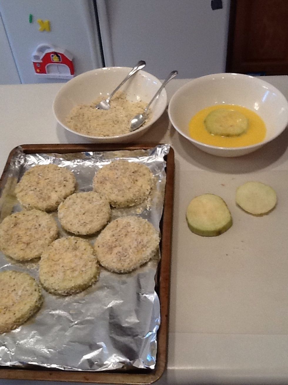Set up your breaking station like this.  Working counter-clockwise, take eggplant slices and coat with egg mixture.  Then add to breadcrumbs and coat well.  Place eggplant slice on baking sheet.