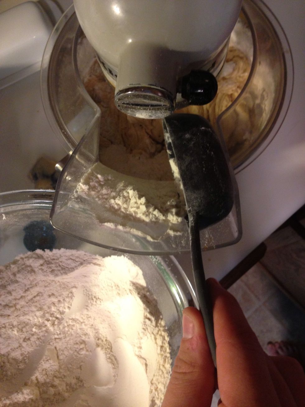 Set your mixer to low and start adding your sifted flour about a 1/2 cup at a time. You don't want to mix too much here, so go ahead and just keep adding flour. Once all the flour is mixed in, stop.