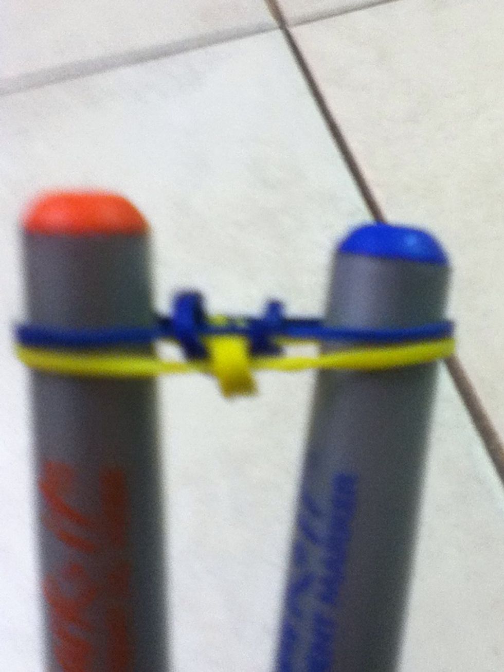 Seventh, Do the same you did for the yellow always take the bottom rubberband and bring it over the sharpies