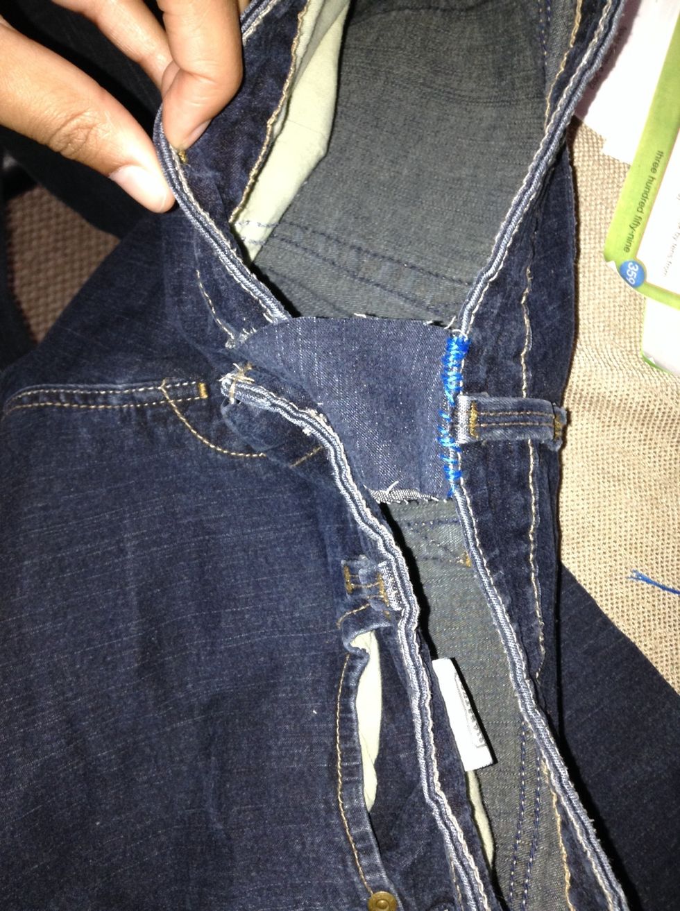 Sew on the strip to the back of the jeans and cut a slit into the other side to loop around the jean buttons.