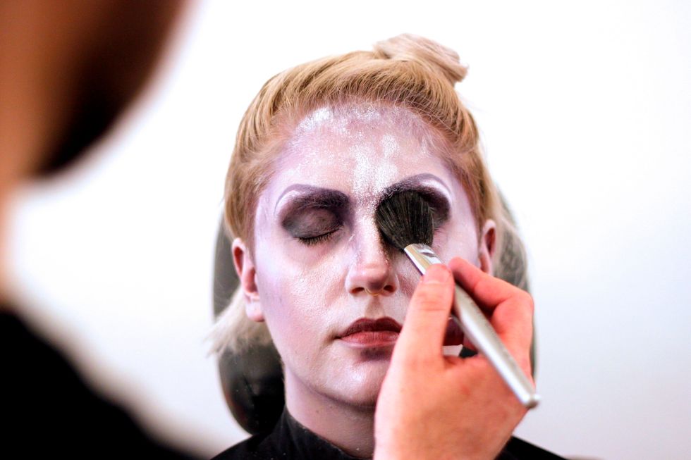 Shade in the eye sockets with black. Then brush with setting powder.