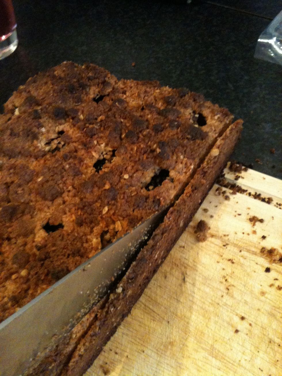 Shake the tin, place your hand out and tip the cake on to your hand. Place on a baking tray. These edges maybe crispy. Cut about 1/2cm round the cake.  Eat trimming if you like.