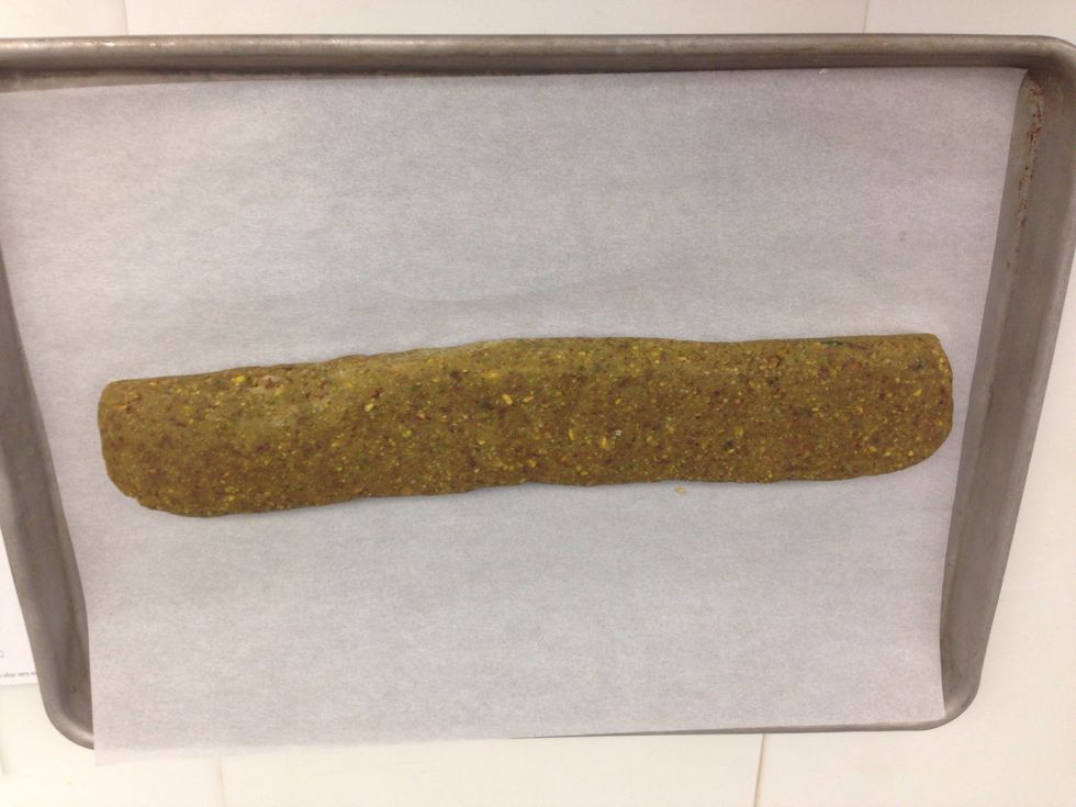 Shape dough into a biscotti log onto a sheet tray lined with parchment paper (pressing dough down slightly with your hand to 3/4 inch thick).