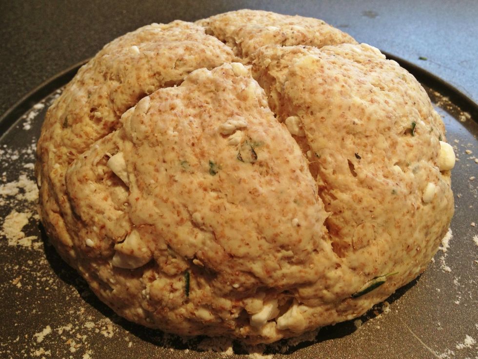Shape into a ball and place on a floured baking tray. Cut a deep cross into the dough and sprinkle with flour or seeds. Bake for 20-30 minutes or until the loaf sounds hollow when you tap the bottom.