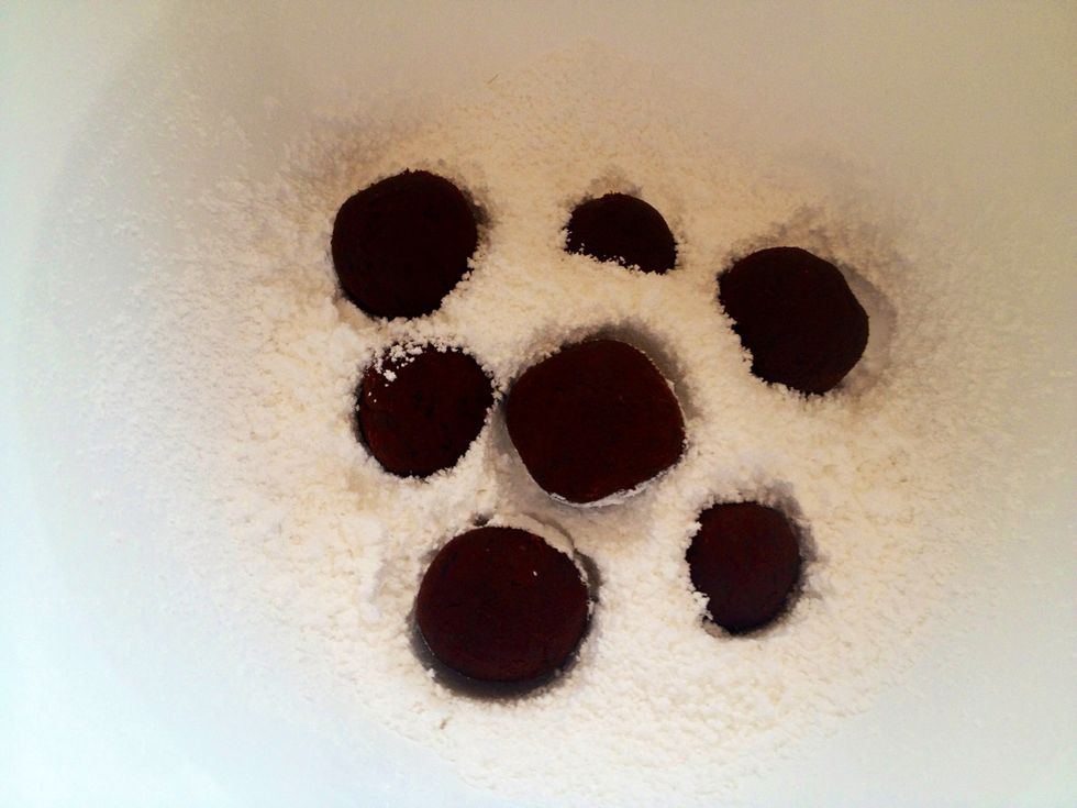 Shape the dough into small 1 inch balls and place them in the confectioners sugar.