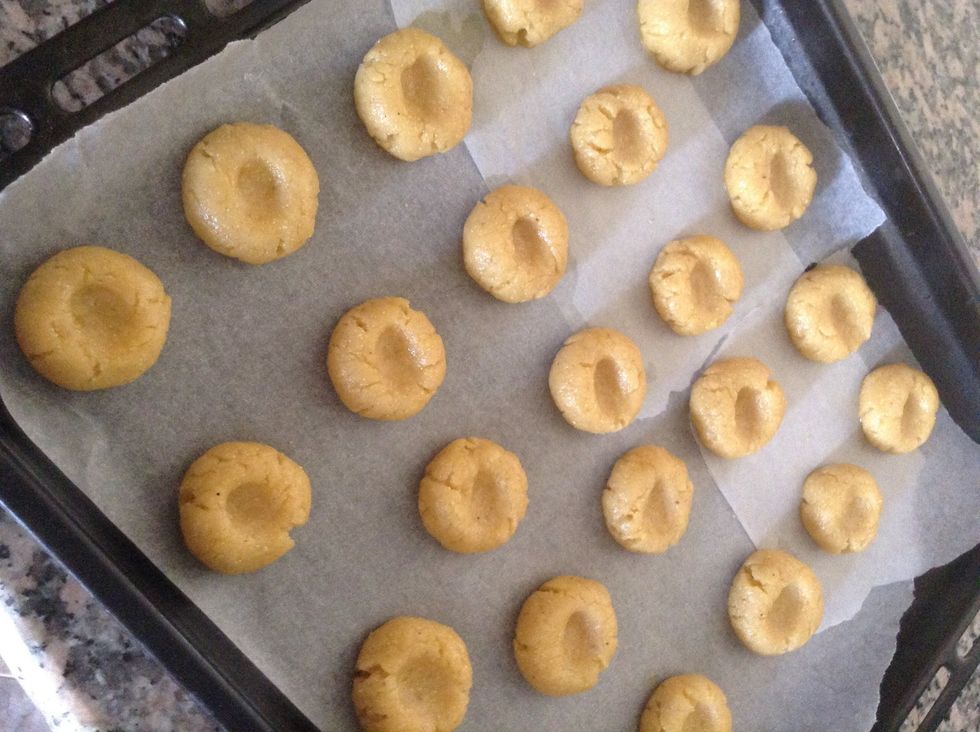 Shape them into small round balls and place them on baking tray with baking paper or parchment paper , after placing press your thumb gently to get the desire shape