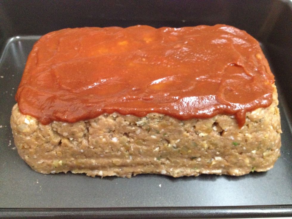 Shape your meat mixture into a loaf shape and place into a baking pan. Top with the ketchup.