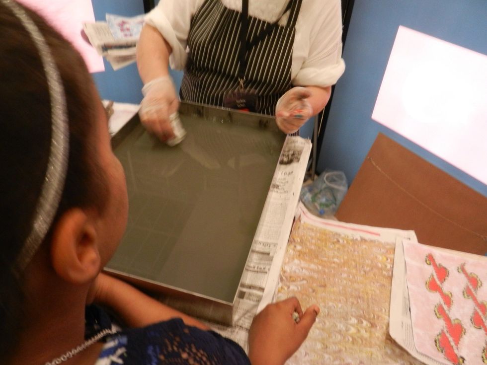 She starts with a water-filled tray. The same water is used repeatedly. She will place newspaper on the water in between painting to remove any paint residue.