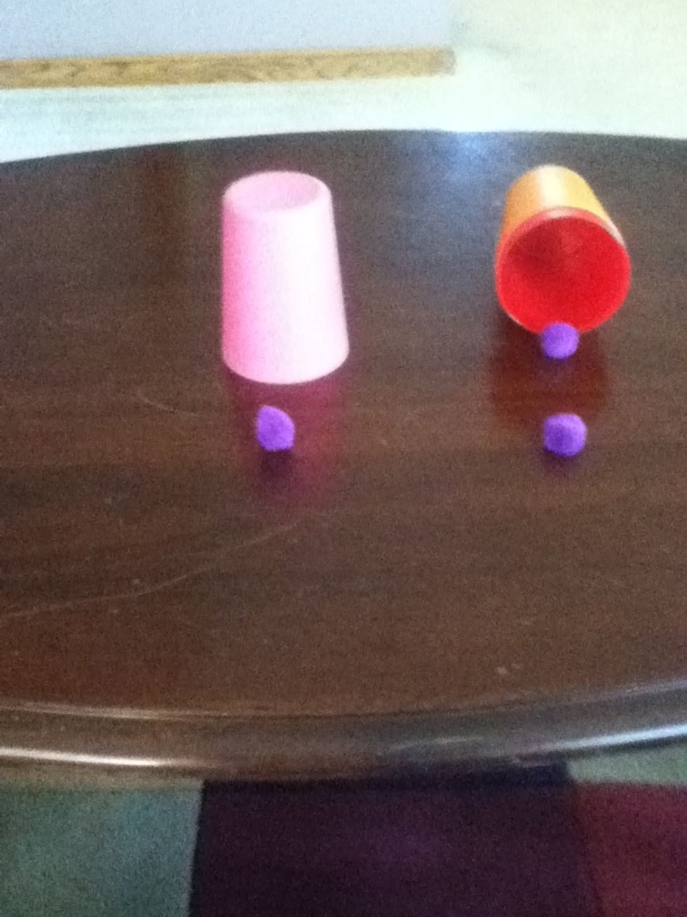 Show the inside of the cup to the audience and point at the ball