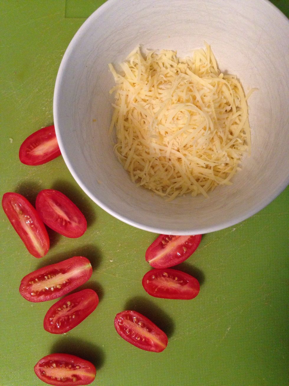 Shred the rest of the cheese and cut some tomatoes in half.