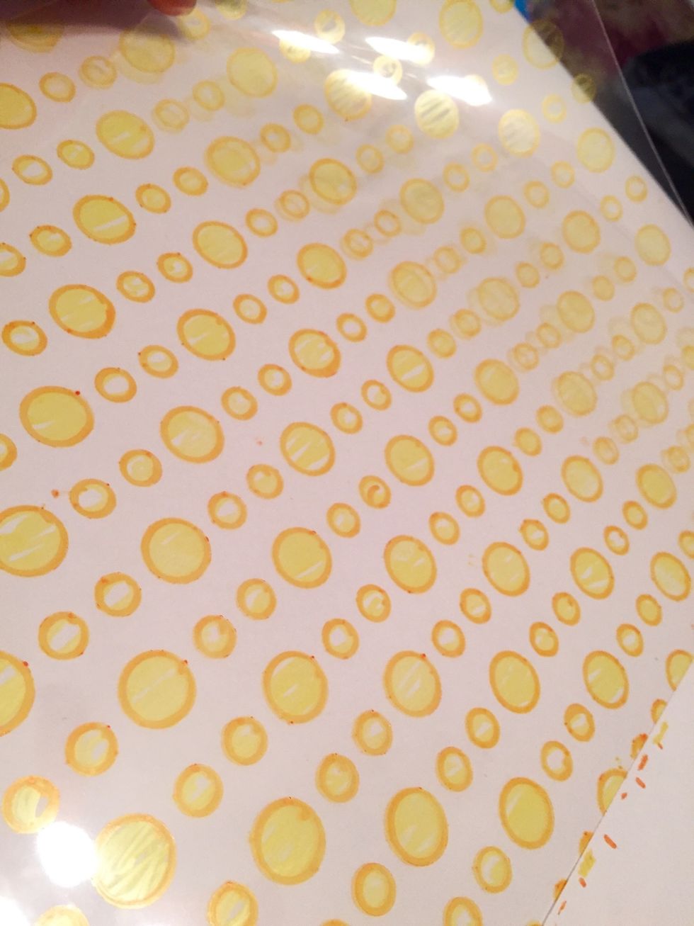Shrink Film sheet after circle design has been completed. place sheet face down on work surface and tape back down. adding designs to both sides of the Shrink Film adds depth to your finished pieces.
