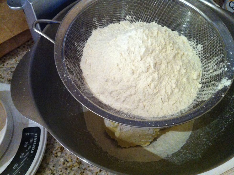 Sieve flour and confectioners sugar into butter and mix.