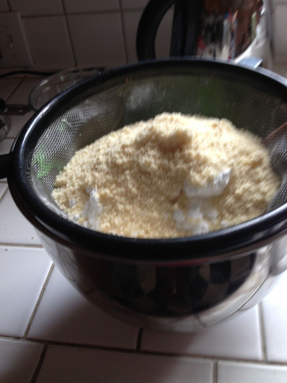 Sift powdered sugar and almond meal into egg whites then add zest
