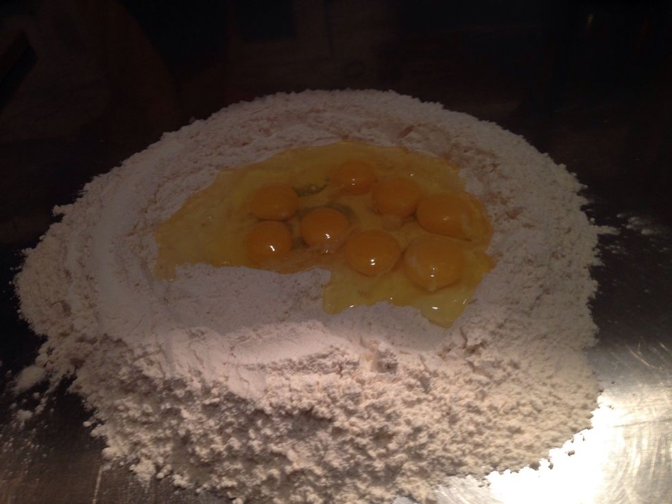 Sift the flour in a big table, make a whole in the middle and pour the eggs, water and salt.