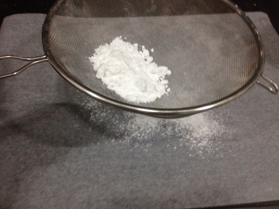 Sift the icing sugar all over the parchment paper.