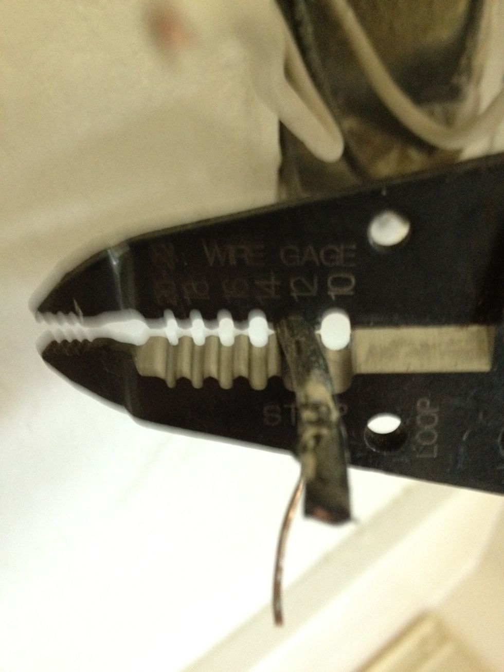 Since I clipped the wires when I removed the old receptacle I need to re-expose the bare copper wire to make a clean connection to the new outlet. I use the wire strippers to remove the insulation.