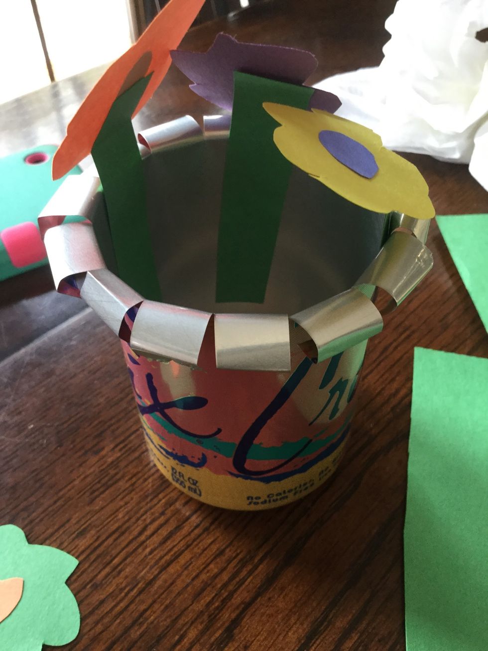 Since I did not have pipe cleaners, I used double sided tape to tape the flowers to the edges of the can. Bending them in different directions will allow them to cover the entire opening.