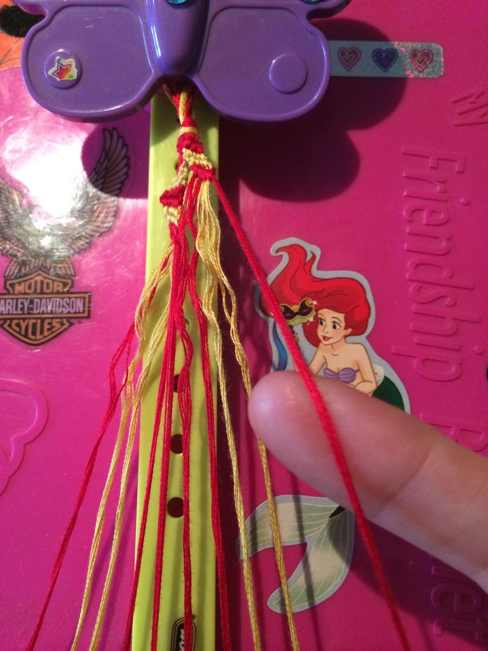 Since this side was done with Forwards knots we will be switching to Backwards knots. Grab the red string and make your way across the other strings.