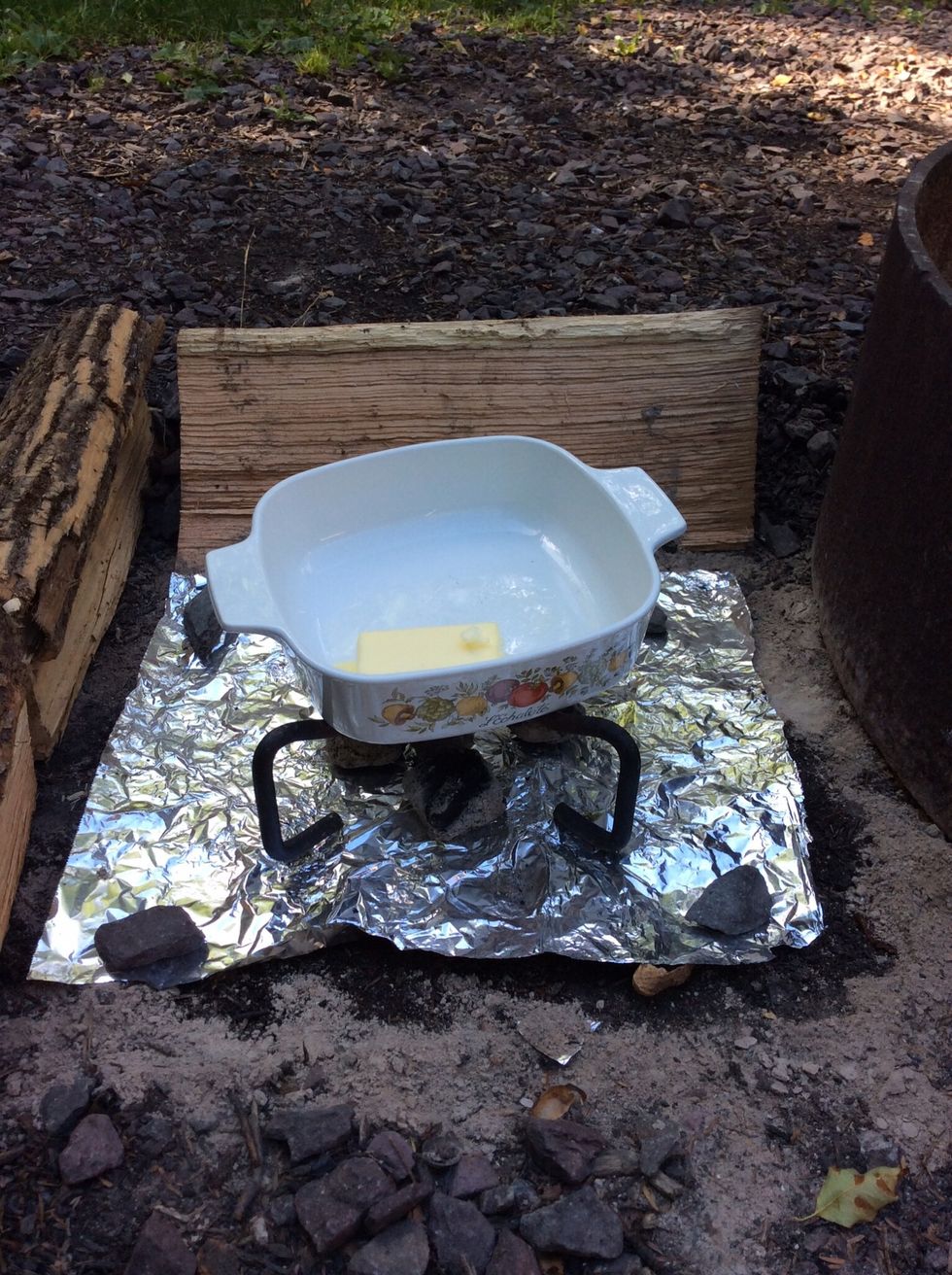 Since this whole dessert is created outside, I created a little stove using hot coals and a cast iron lid stand to melt 3/4 stick of butter.