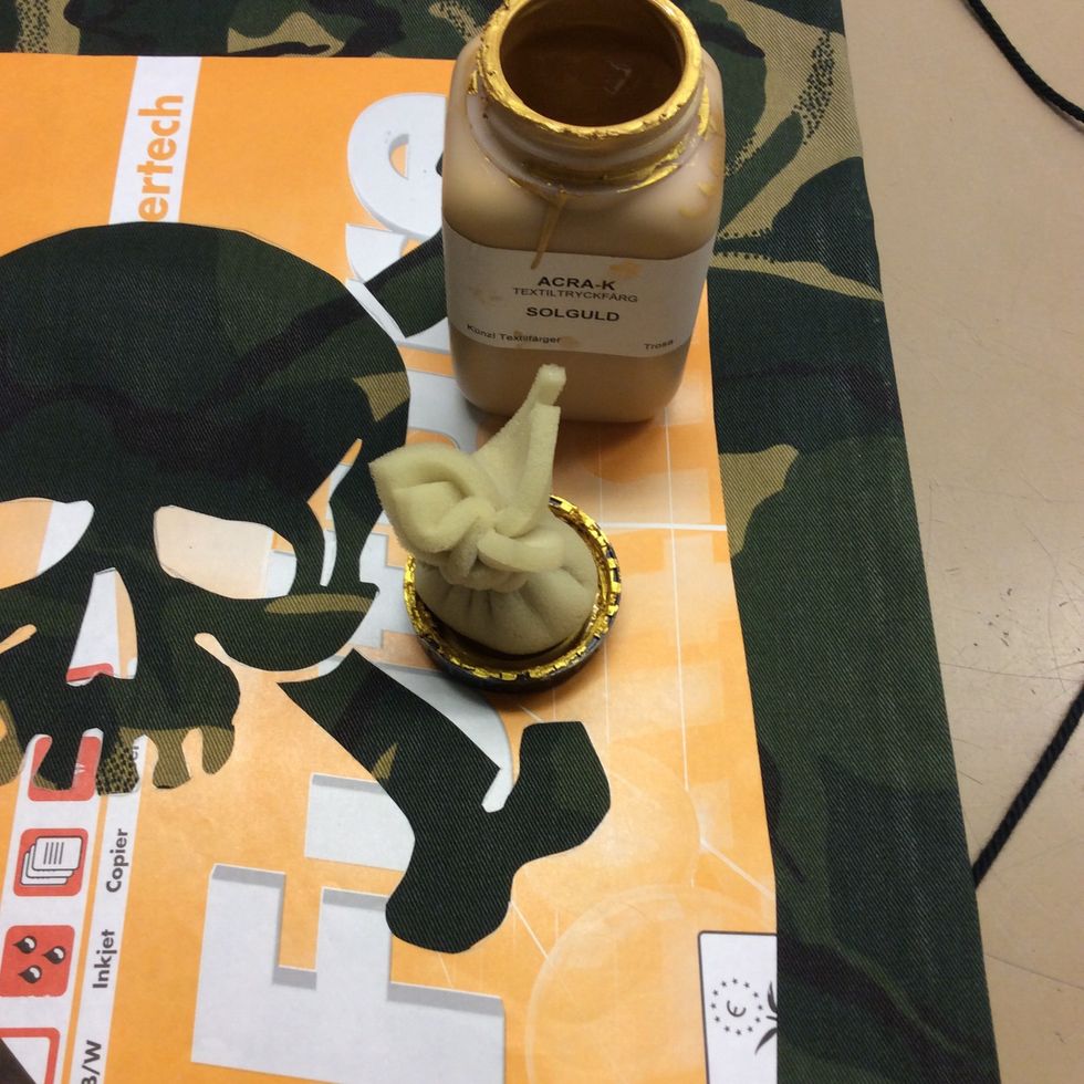 Skaka f\u00e4rgen, tryck skumgummidutten i locken f\u00f6r att suga upp f\u00e4rg i skumgummit. \u00d6verfl\u00f6dig f\u00e4rg p\u00e5 skumgummit skrapas av i f\u00e4rgburken igen s\u00e5 att de inte blir f\u00f6r mycket f\u00e4rg p\u00e5 tyget.