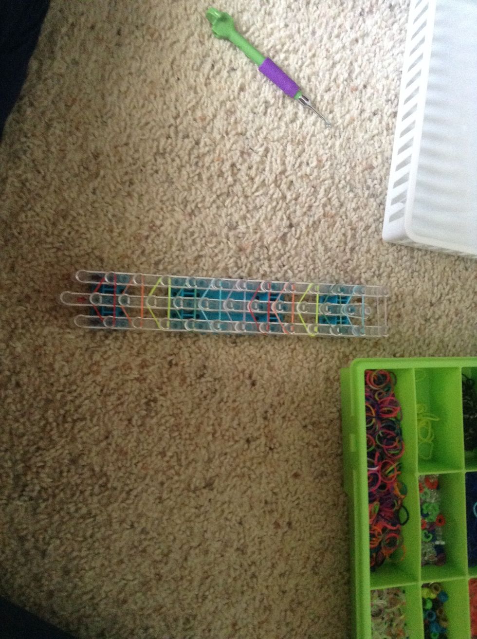 Skipping the first peg in each row make a triangle of red then then yellow and green and blue and purple can continue until you run out of room for a triangle