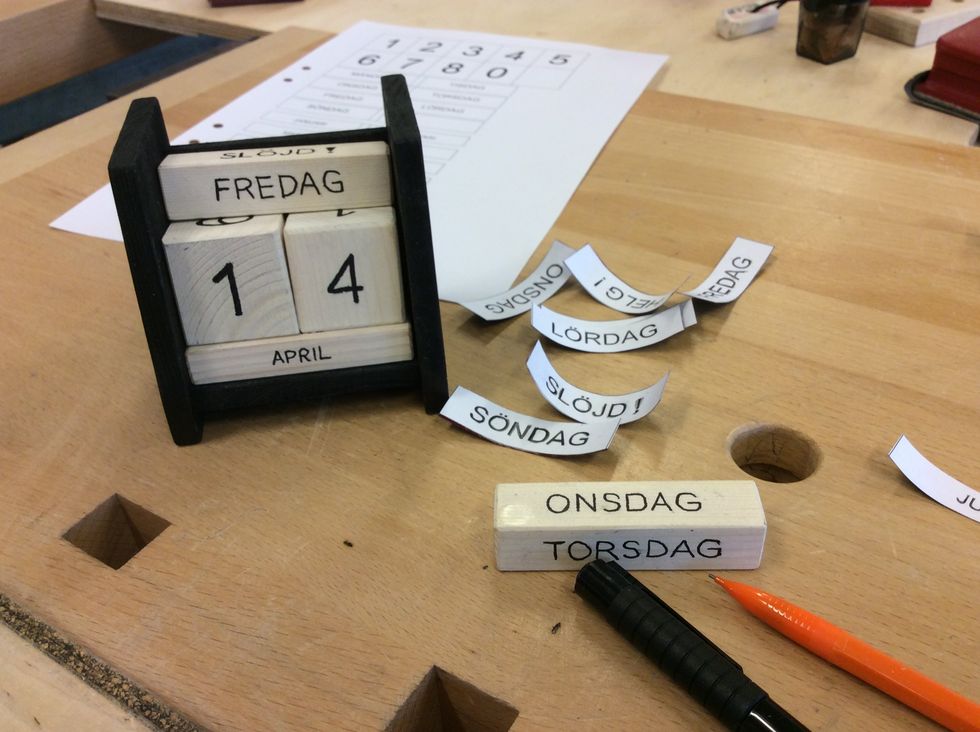 Skriv text och datum p\u00e5 kalendern. H\u00e4r finns det stor chans att dekorera och skapa sitt eget utryck. Anv\u00e4nd f\u00e4rg eller br\u00e4nnpenna. Anv\u00e4nd siffror du hittat i tidningar, det kan f\u00e4stas med decopagelack
