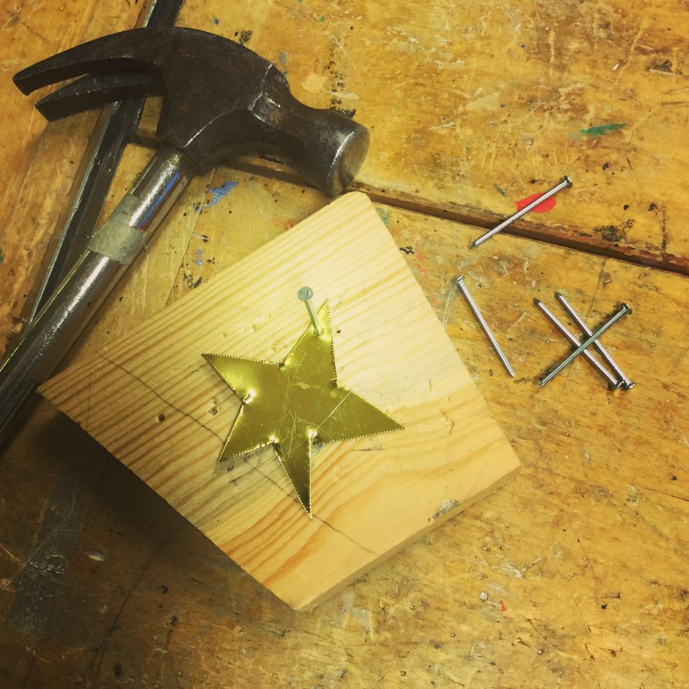 Sl\u00e5 ett h\u00e5l i ena spetsen. Sl\u00e5 igenom en spik, t\u00e4nk p\u00e5 att ha en skr\u00e4pbit som underlag s\u00e5 att du inte f\u00f6rst\u00f6r b\u00e4nken.