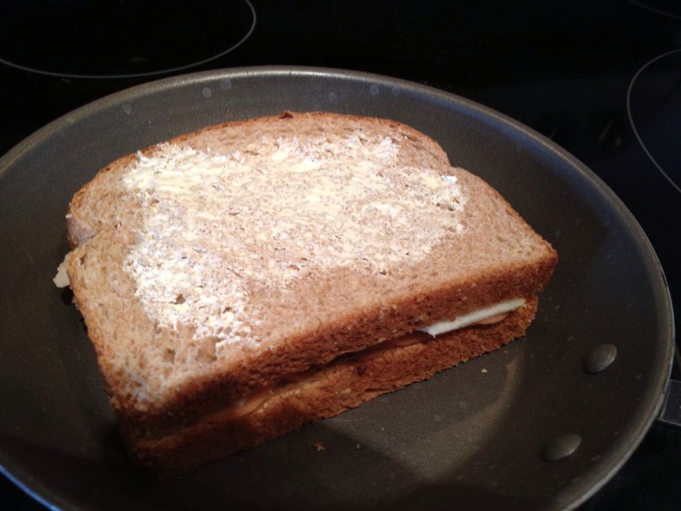 Slap your sandwich down (butter side down), and then butter the other side. You should put the sandwich on early so the cheese has time to melt before the bread gets too dark
