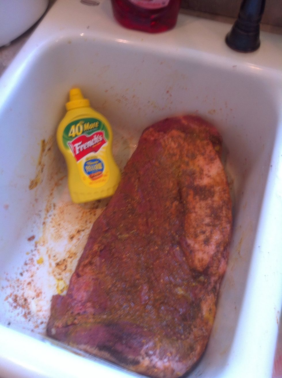 Slather with mustard then sprinkle with rub. Massage into meat.