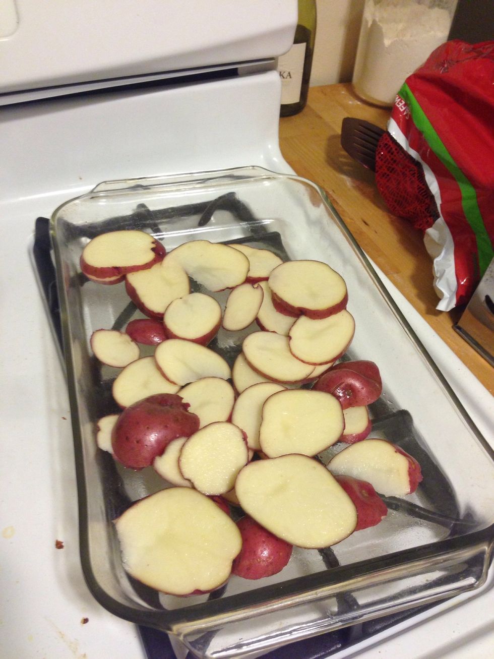 Slice 4 medium red potatoes and add them to a pan (with nonstick spray). Make sure they are even so they cook at the same rate.