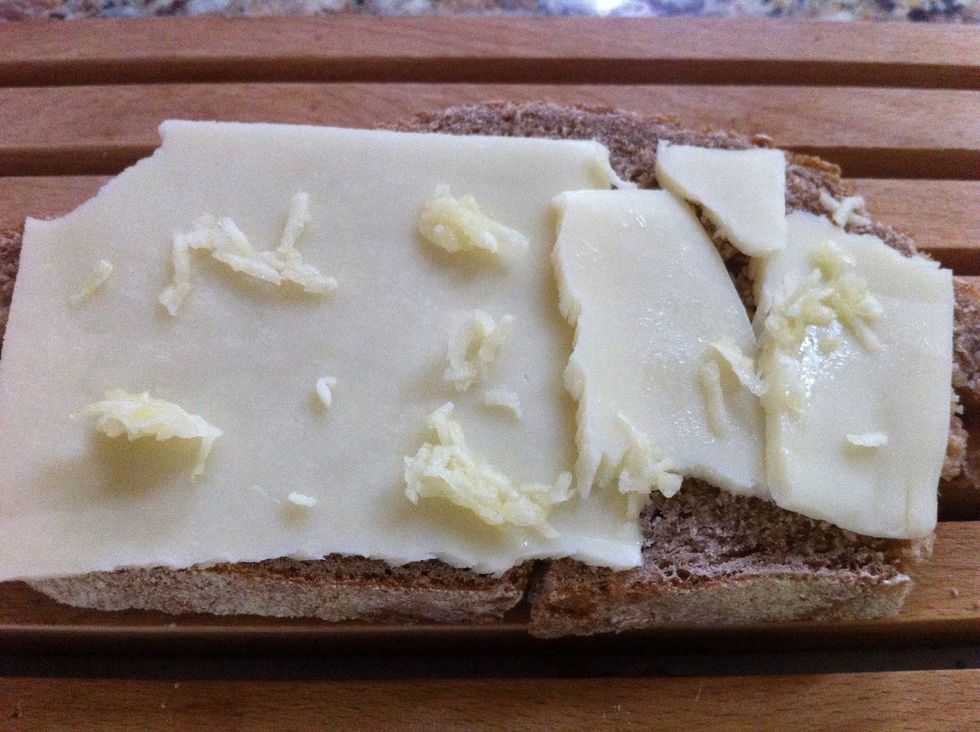 Slice bread and layer with desired amount of cheese. Sprinkle with chopped garlic. If you want a lower calorie sandwich opt for less cheese and a whole grain bread.