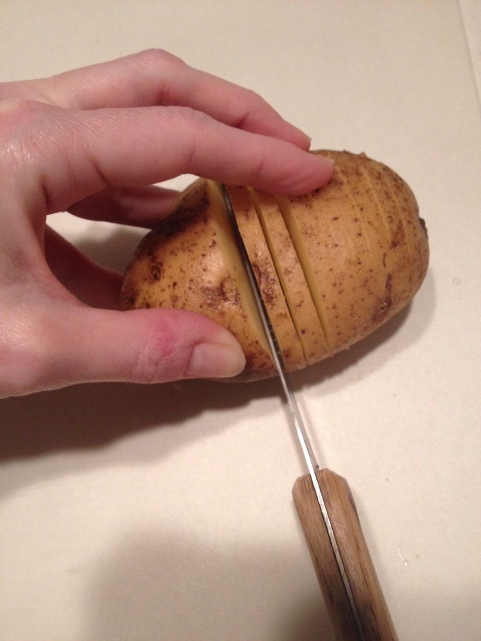 Slice each potato like this, but do NOT slice all the way down. Slice about 3/4 down as the slices will fan out when baking.