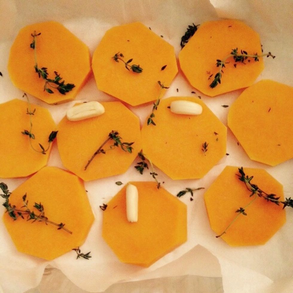 Slice it into discs and place it in a baking tray with a sheet of wax paper. Add the halved garlic cloves and sone thyme. Bake for 20min at 180C, reduce the temperature if it starts roasting