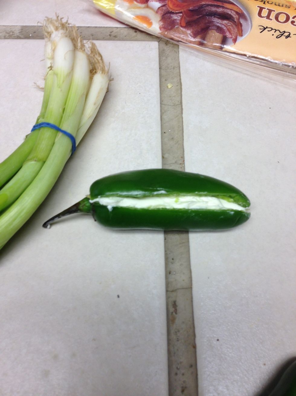 Slice jalape\u00f1o length wise. Peel & remove all inners and seeds.Stuff either cream cheese or cheddar cheese in the jalape\u00f1o. Example of cream cheese stuffed jalape\u00f1o pepper.