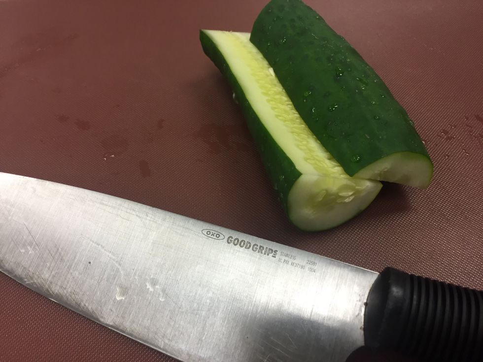 Slice off a fourth of the edge of the cucumber. Toss the bigger half to the side.
