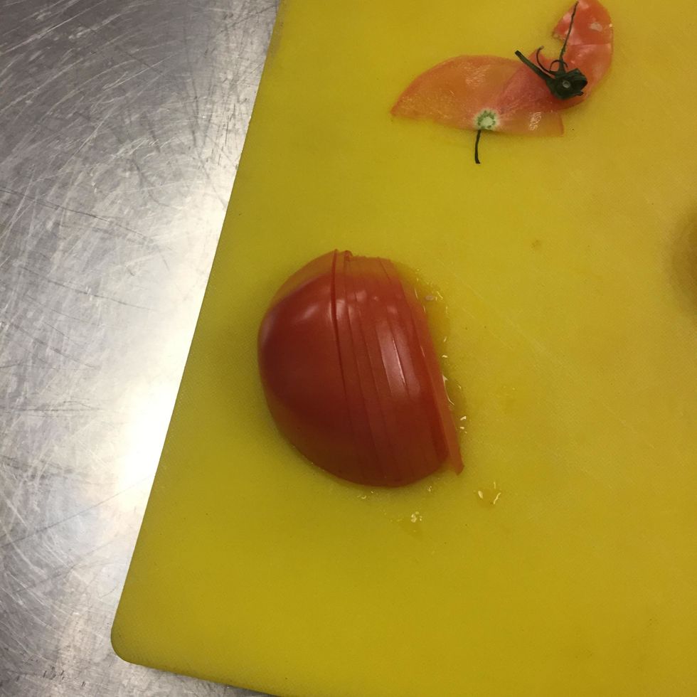 slice off the edge then slice the tomato half into extremely thin slices. it is important that all the slices stay in order.