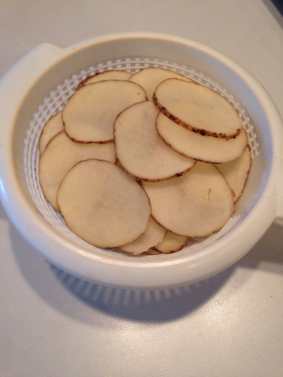 Slice potatoes. The thinner the slice, the crispier the potatoes will be and it will require more of the oil mixture to coat.