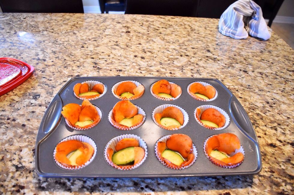Slice sweet potatoes thinly on a mandolin. Lightly sprinkle olive oil to coat. Season with salt and pepper. Slice zucchini slices. Lay inside a paper baking cup. Wrap edges with sweet potato.