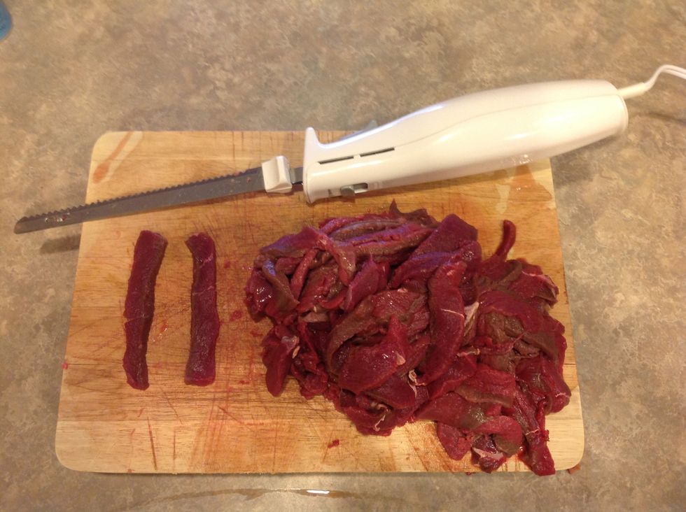 Slice thawed meat into thin strips using an electric knife