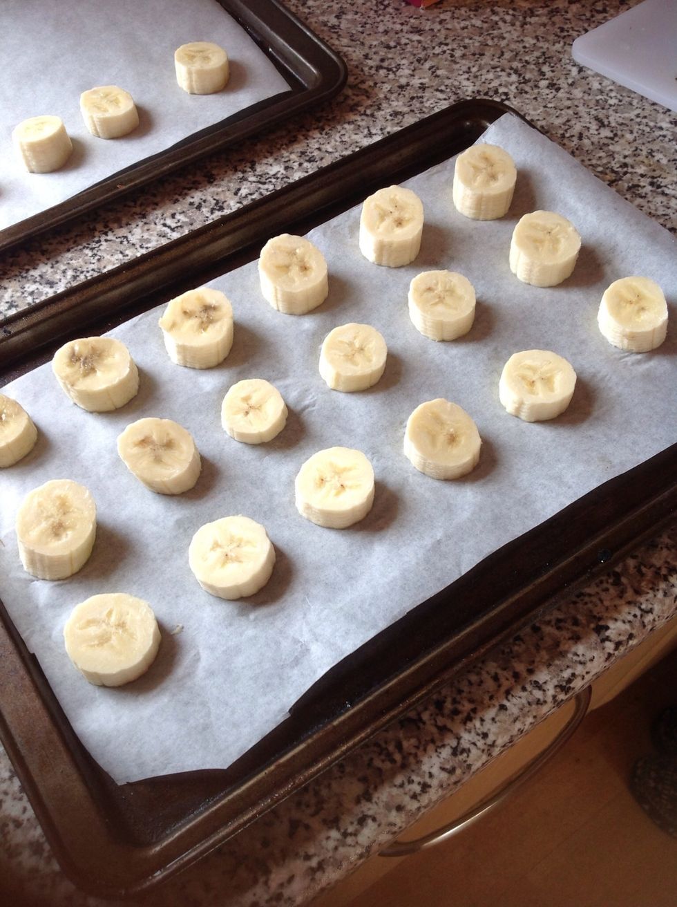 Slice the bananas and put them on a baking tray lined with grease proof paper.