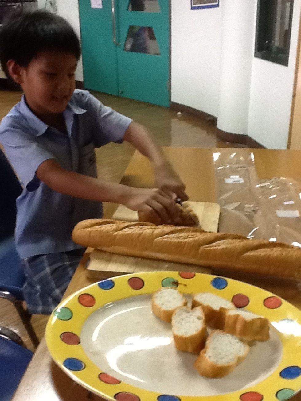 Slice the bread into small pieces. The bread pieces are the pizza bases.