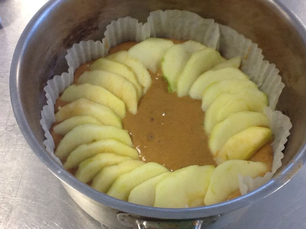 Slice the cooking apples into segments and arrange them on the top of the cake