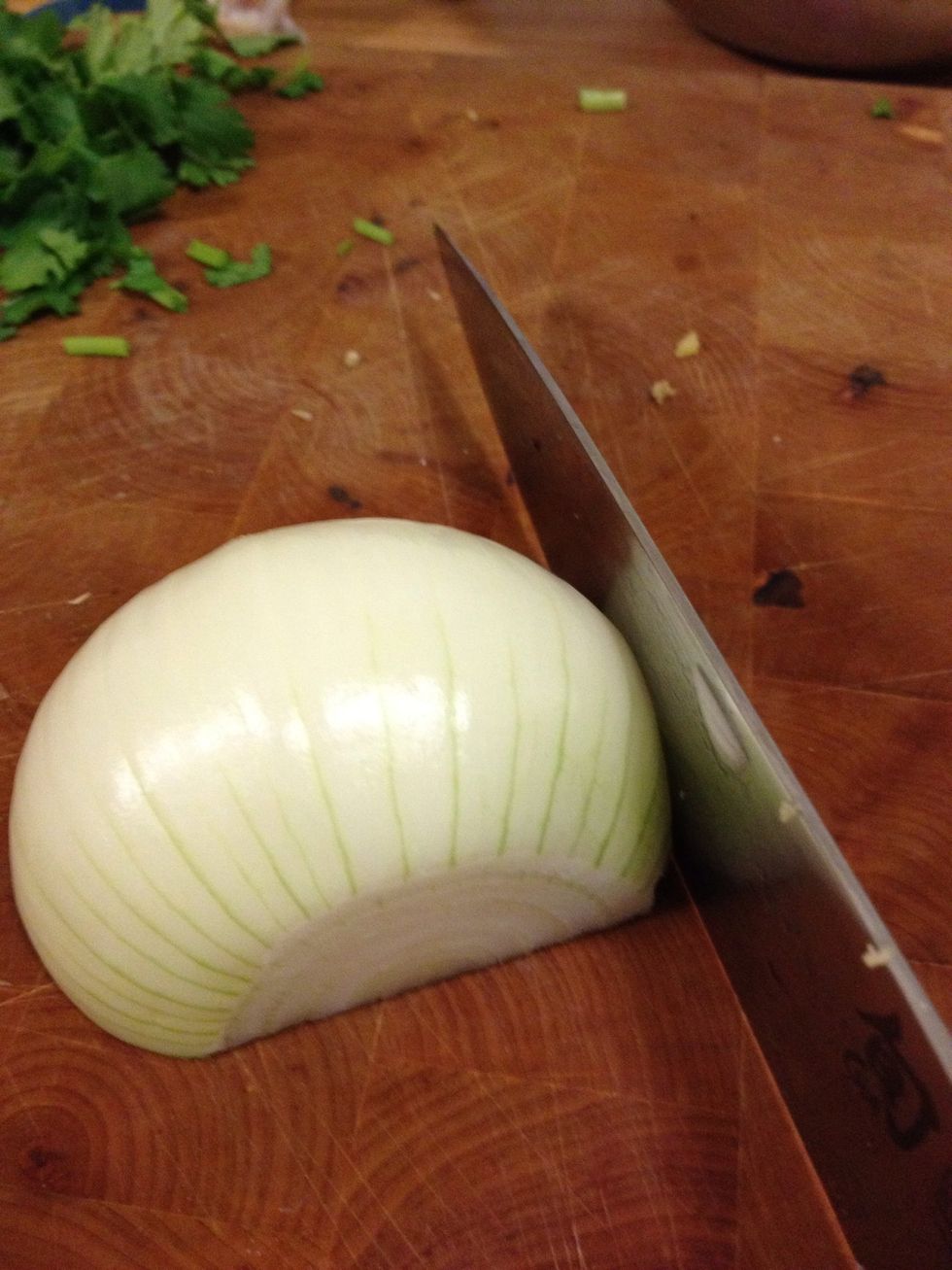 Slice the ends off the onion then halve through both ends. Place flat side down and slice thinly like this. The onions will be part of the final texture.