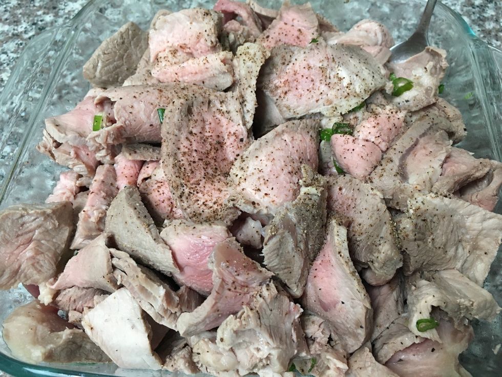 Slice the meat into thin pieces and then season it with ground black pepper and green onions.