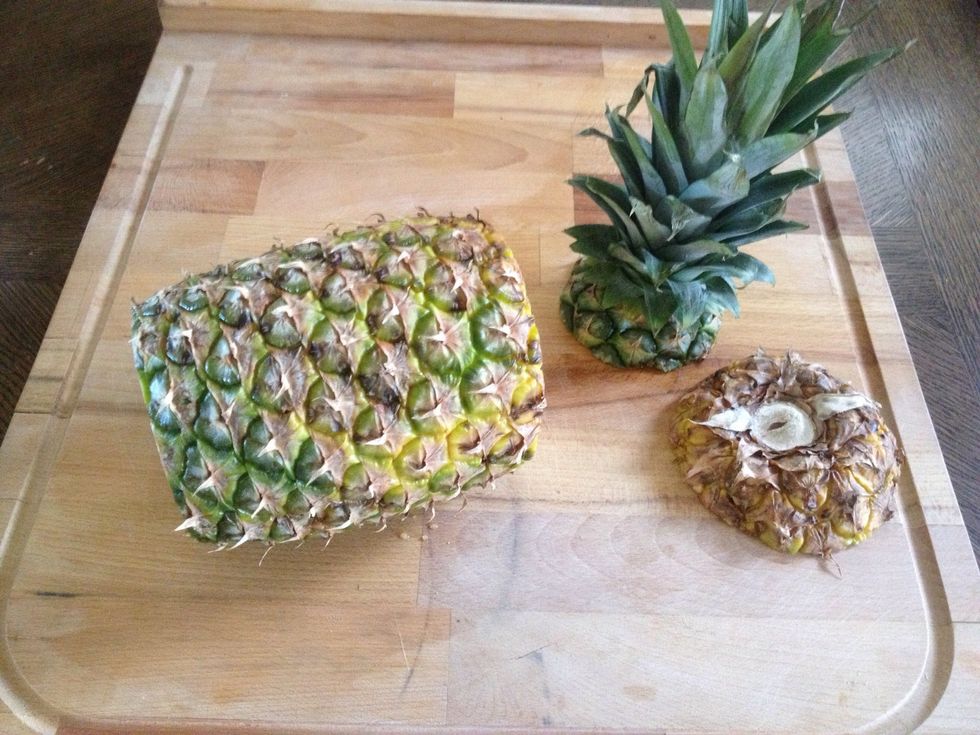 Slice the pineapple stalk and the bottom using a sharp serrated knife.